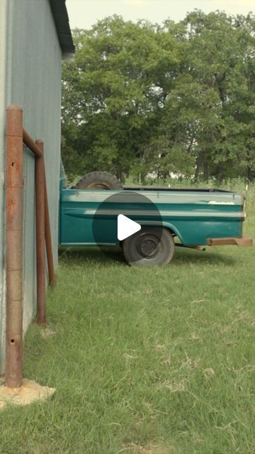 an old green truck is parked in the grass