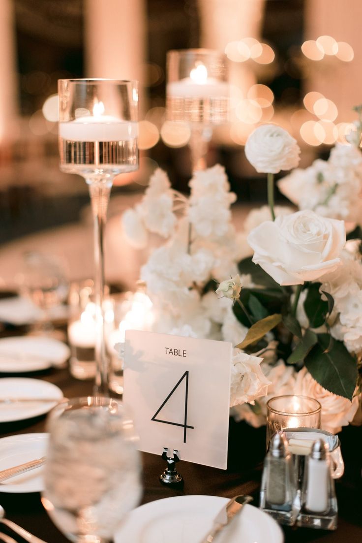 the table is set with white flowers and candles