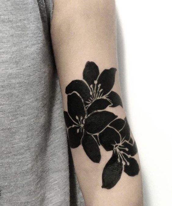 a black and white flower tattoo on the arm