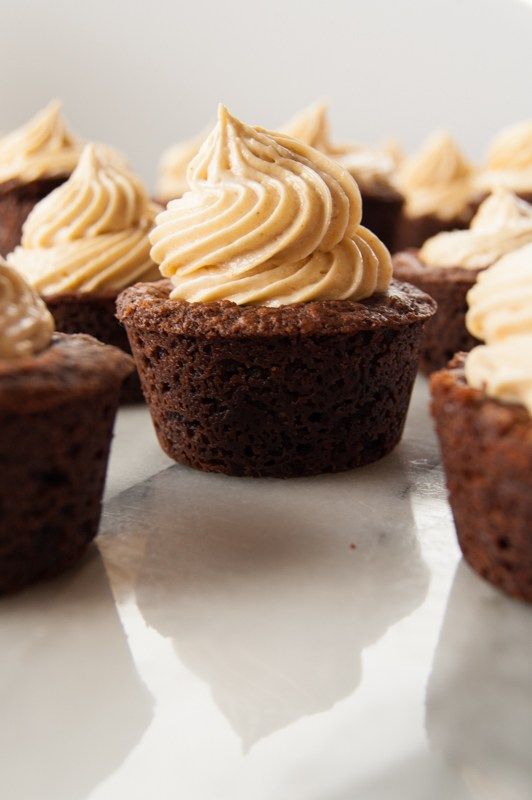 several cupcakes with frosting on them sitting on a table