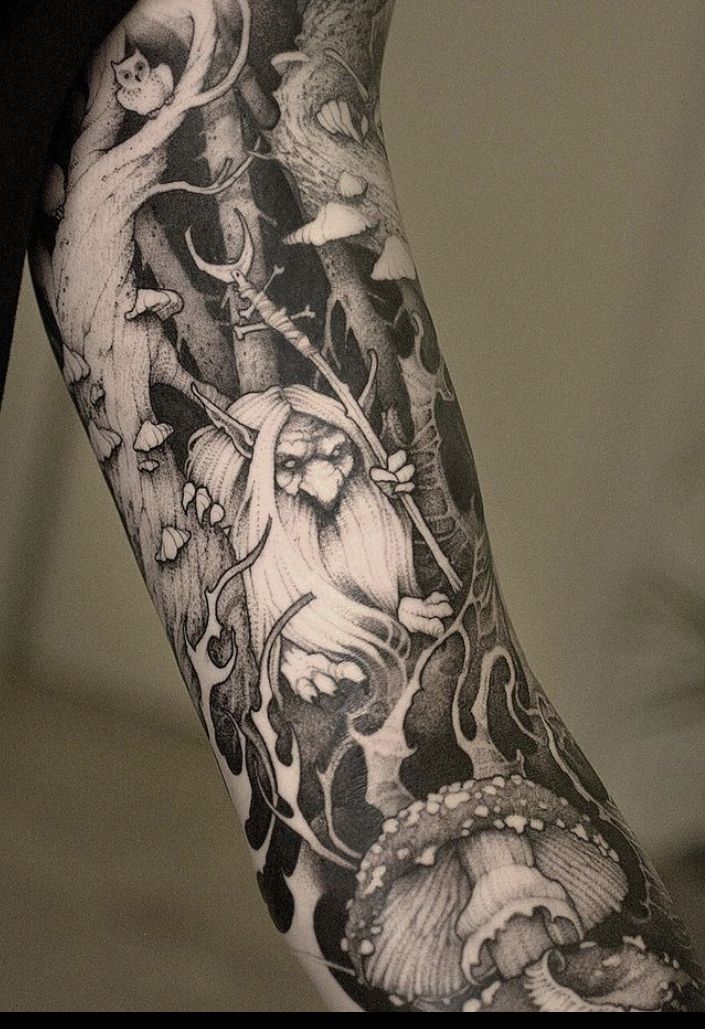 a man's arm covered in black and white art work with an owl on it