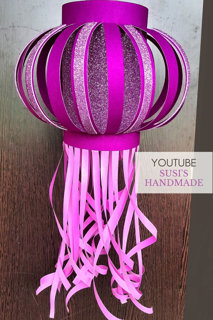 a purple hat with pink streamers on top of it and the words youtubetube handmade above it