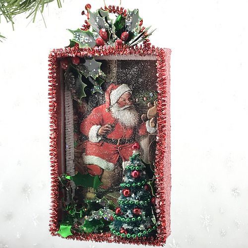 a christmas ornament hanging from a tree with santa clause on it's back