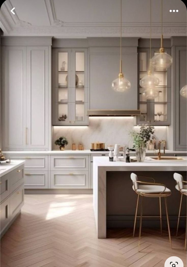 a kitchen with white cabinets and wooden floors, two bar stools in front of the island