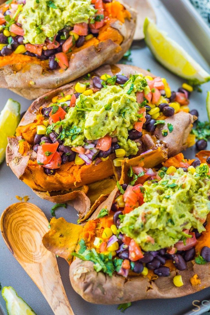 baked sweet potatoes topped with guacamole, black beans and cilantro