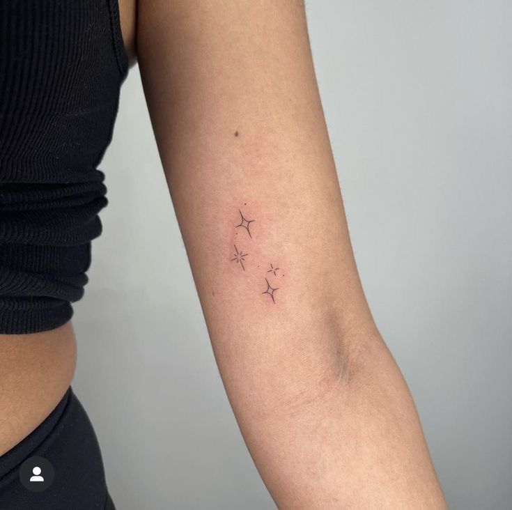 a woman's arm with three stars tattoo on the left side of her arm