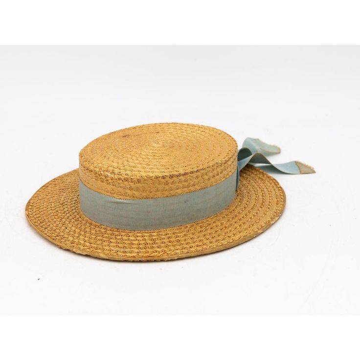 The Ridgemont Make's vintage 1930s boater hat showcases timeless elegance with its natural straw construction. Adorned with a pale blue ribbon and bow, this hat epitomizes classic style. The sturdy yet lightweight straw provides comfort and durability, while the charming ribbon adds a touch of sophistication. This boater hat captures the essence of vintage summer fashion, making it a coveted accessory for collectors and design enthusiasts alike. Seven are available for a display collection. Some Vintage Blue Adjustable Hat Bands, Vintage Adjustable Boater Hat With Flat Crown, Vintage Hat Bands For Beach With Flat Crown, Vintage Flat Crown Hats For Beach, Vintage Flat Crown Hats For The Beach, Vintage Hat Bands With Flat Crown For Summer, Vintage Straw Boater Hat With Flat Brim, Vintage Straw Boater Hat For Garden Party, Vintage Natural Boater Hat With Short Brim