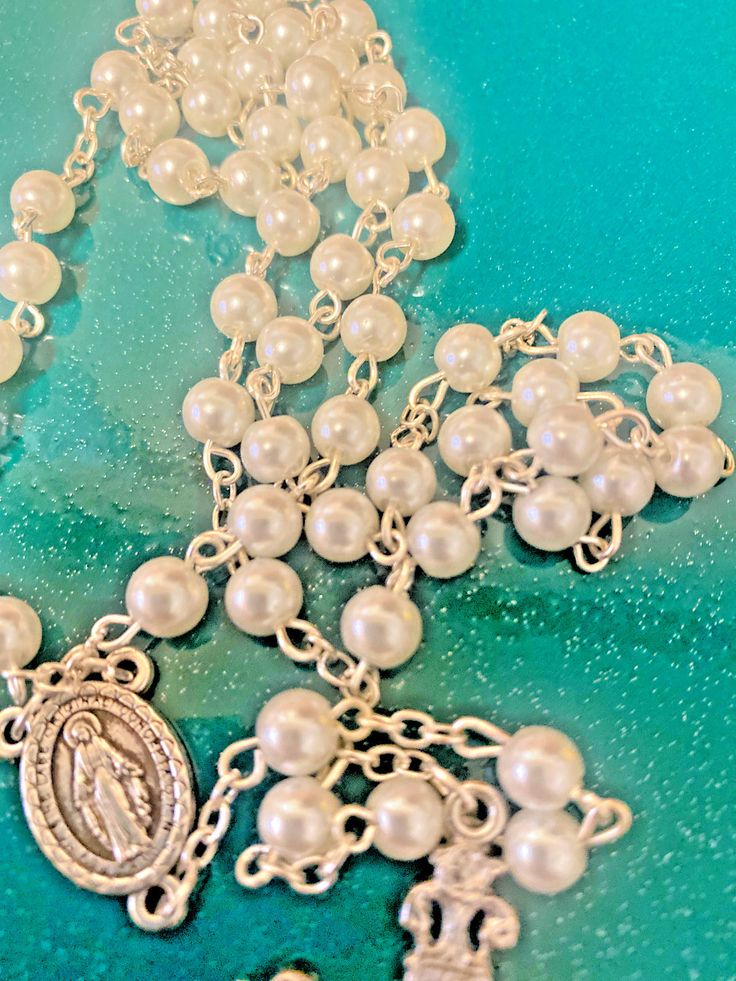 ITEM #AB-093 You are purchasing a beautiful white faux pearl rosary. Comes with acrylic case ready to oobe gifted or for you to carry in you purse, pocket, etc. It Measures approximately 21" long, the beads are 6mm. Please see pictures for details.aasaa ***************************************************************** Please visit our other Ebay listings to find more books and DVD written by Bob and Penny Lord and all of our other religious items. If you have any questions please let us know. We Silver Pearl Rosary With 8mm Beads, Elegant Silver Rosary For First Communion, Elegant Pearl Beaded Rosary, Elegant Pearl White Pearl Rosary, Elegant Beaded Rosary For Jewelry Making, Elegant Pearl Rosary For First Communion, Spiritual Pearl Rosary As Gift, Elegant Pearl Rosary With 8mm Beads, Elegant Pearl Rosary With Round Beads