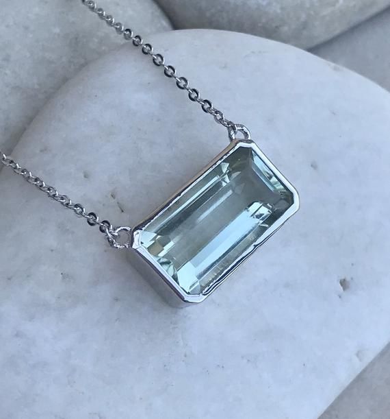 A collection of Emerald-Cut Rectangle Shaped Green Amethyst handcrafted in sterling silver with a high polish, fastened on a sterling silver chain with Belesas and 925 stamped on pendant, makes a great statement necklace for those Amethyst(February) Birthdays! Wrapped in a box ready for gift giving.(n-179-3) Green Amethyst 19mmL x 9.5W x 7.2mm Depth16" Chain length with 1" extender total length 17"*Follow us @belesasjewelry on Instagram for promotions/giveaways*LIKE* us on Facebook http://www.fa Sterling Silver Gemstone Necklace, Green Stone Necklace, Random Crafts, Bezel Necklace, February Birthday, Amethyst Necklace, Amethyst Pendant, Green Necklace, Green Amethyst