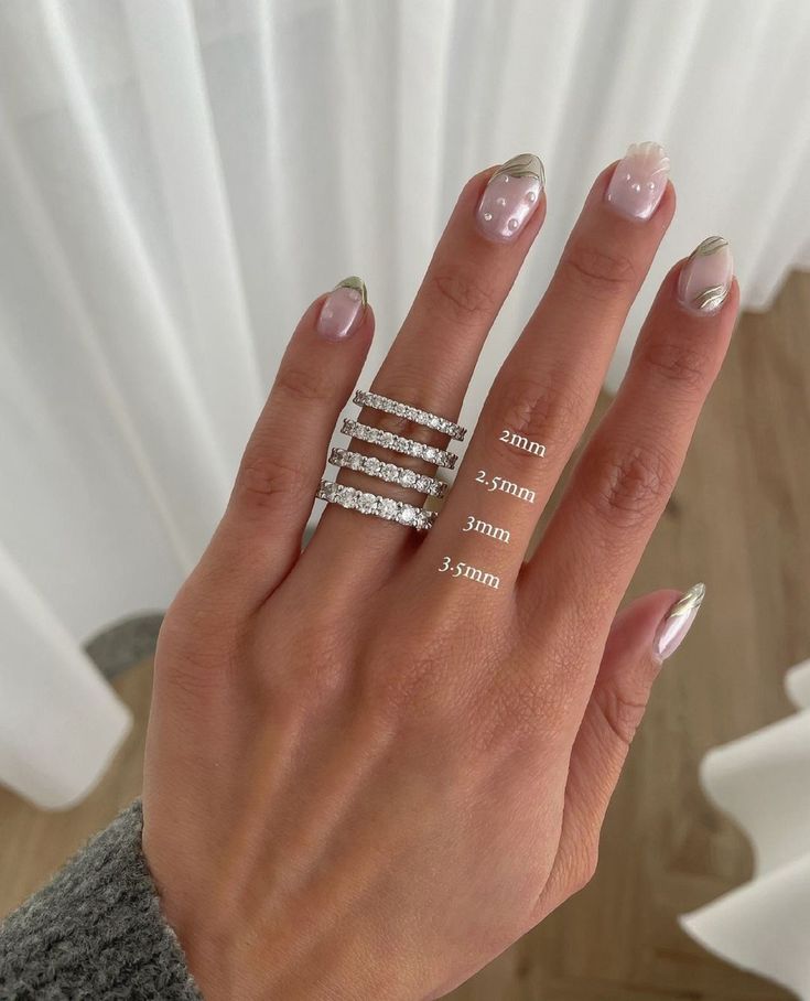 a woman's hand with two rings on her fingers and one ring in the middle