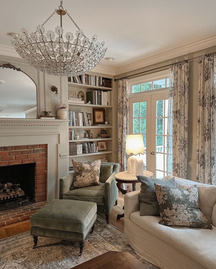 a living room filled with furniture and a fire place under a chandelier in front of a window