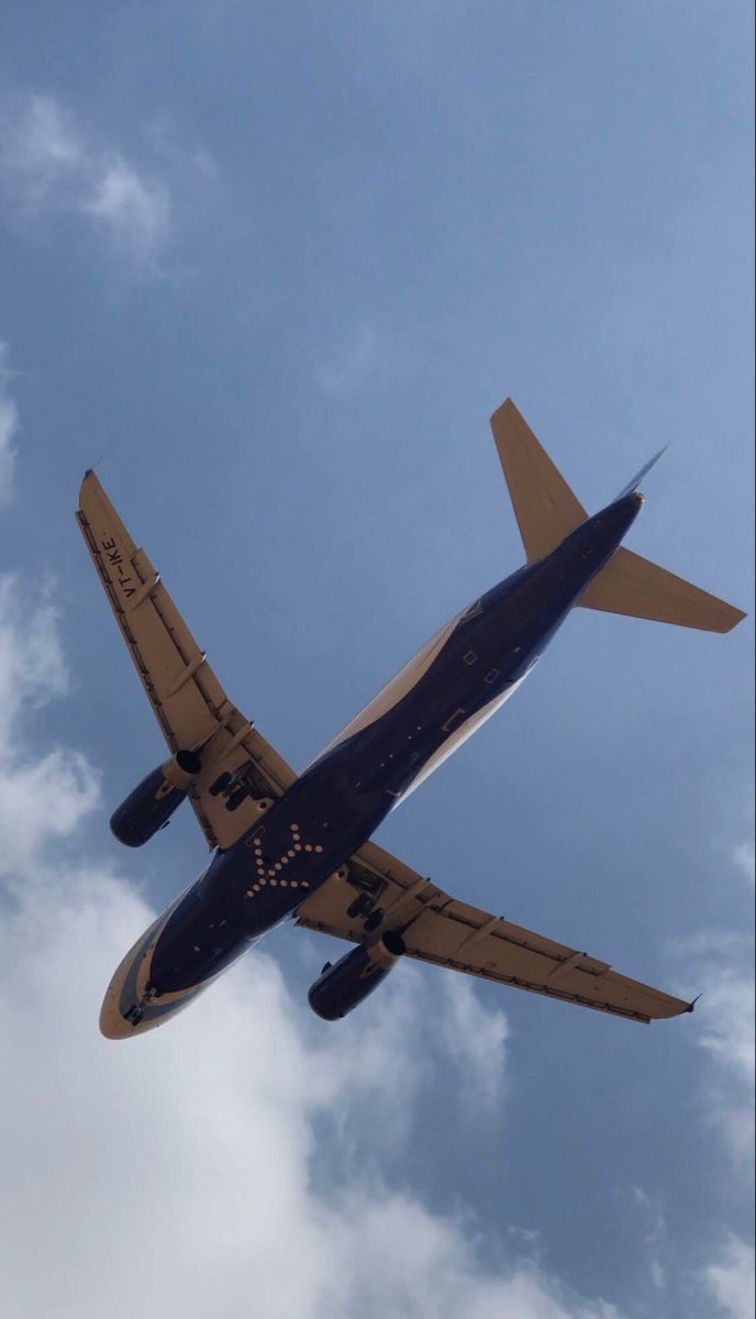 an airplane is flying in the sky on a clear day with some clouds behind it