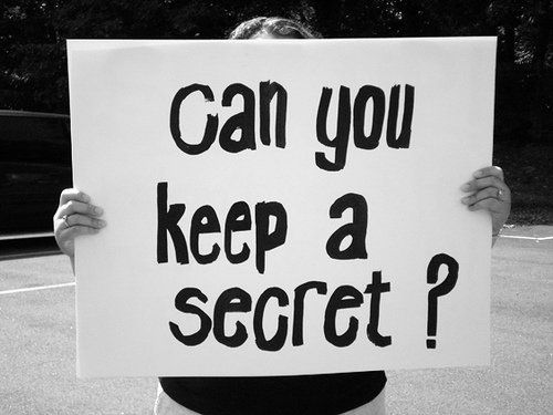 a person holding a sign that says can you keep a secret?