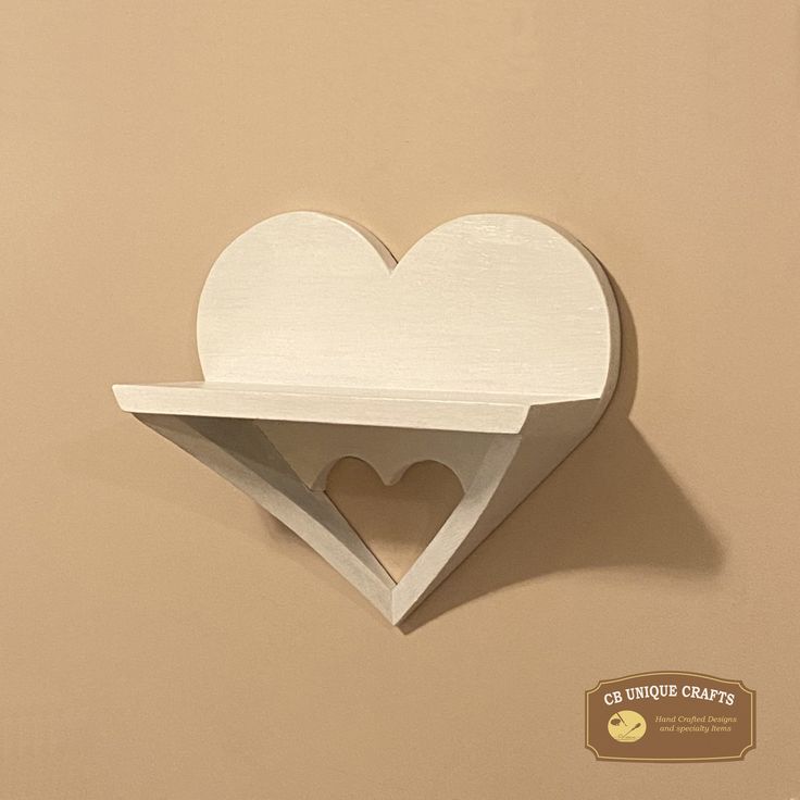 a wooden shelf with a heart cut out of it's sides on a wall