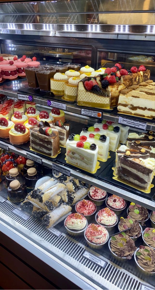 a display case filled with lots of different types of cakes and desserts on top of it