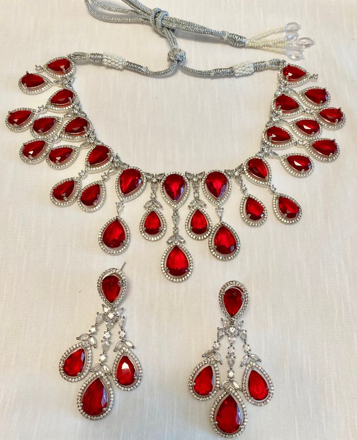 Enhance your jewelry collection with our CZ American Diamond and Red Stone Necklace set. This elegant set is perfect for any party or special occasion. The combination of CZ diamonds and red stones adds a touch of sophistication and glamour. Up your style game and stand out from the crowd with this stunning necklace set. Jewellery Care- Keep the jewellery dry, avoid contact with perfumes and water. Red Stone Necklace, Gold Haram, Stone Necklace Set, Red Stones, Bridal Choker, Gem Necklace, Elegant Sets, American Diamond, Stunning Necklace