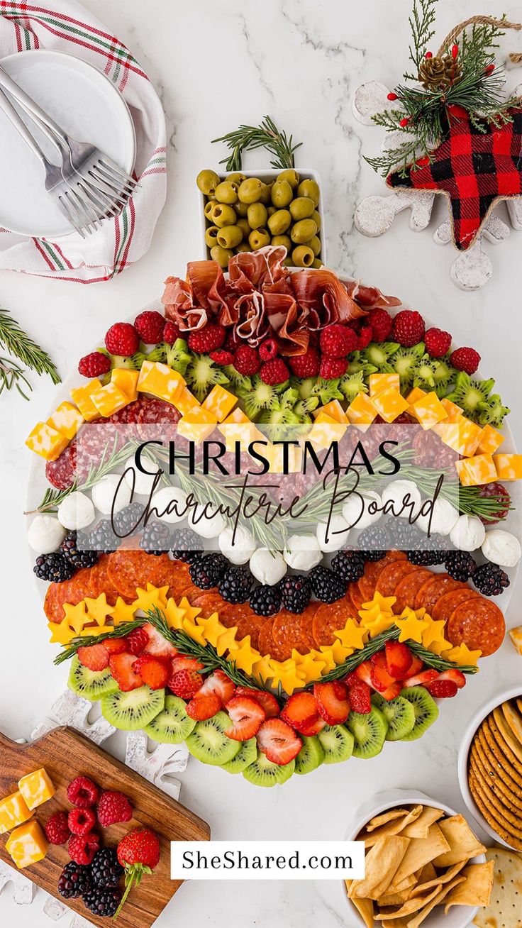 a christmas cheese board with fruit and crackers on the side, surrounded by other holiday foods