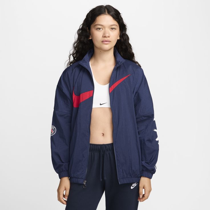 Rep your favorite team in this PSG jacket. An oversized fit and a mesh lining make it perfect for layering, while elastic at the waist and cuffs help keep it in place as you move through your day. Nike Track Jacket For Sports Season In Athleisure Style, Nike Athleisure Track Jacket For Sports Season, Nike Sporty Track Jacket With Ribbed Cuffs, Navy Sporty Long Sleeve Windbreaker, Athleisure Outerwear For Fall Sports Events, Navy Long Sleeve Sporty Windbreaker, Navy Casual Nylon Track Jacket, Nike Sporty Fall Windbreaker, Sporty Team-colored Track Jacket