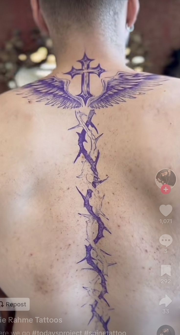 the back of a man's neck with tattoos on it and an arrow in the middle