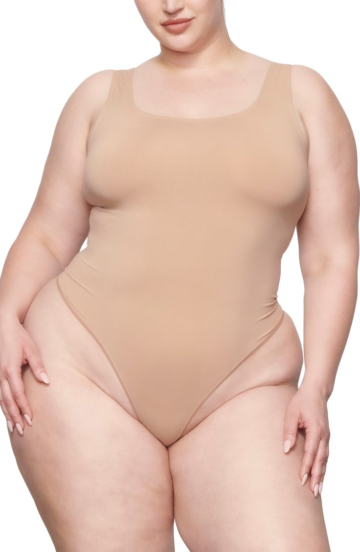 This scoop-neck bodysuit is the perfect everyday essential for light smoothing and support for your waist. It features a double scoop neck and a thong back that make it seamless under clothing. Pull-on style (no snap closure) Scoop neck Thong back Cotton-lined gusset 85% nylon, 15% elastane Hand wash, line dry Imported Seamless Second-skin Backless Bodysuit, Stretch Leotard With Built-in Bra And Scoop Neck, Solid Seamless Backless Leotard, Stretch Bodysuit With Moderate Back Coverage, Seamless Low Back Shapewear For Summer, Second-skin Scoop Neck Leotard, Scoop Neck Second-skin Leotard, Second-skin Scoop Neck Shapewear Swimwear, Summer Scoop Neck Seamless Short Sleeve Bodysuit