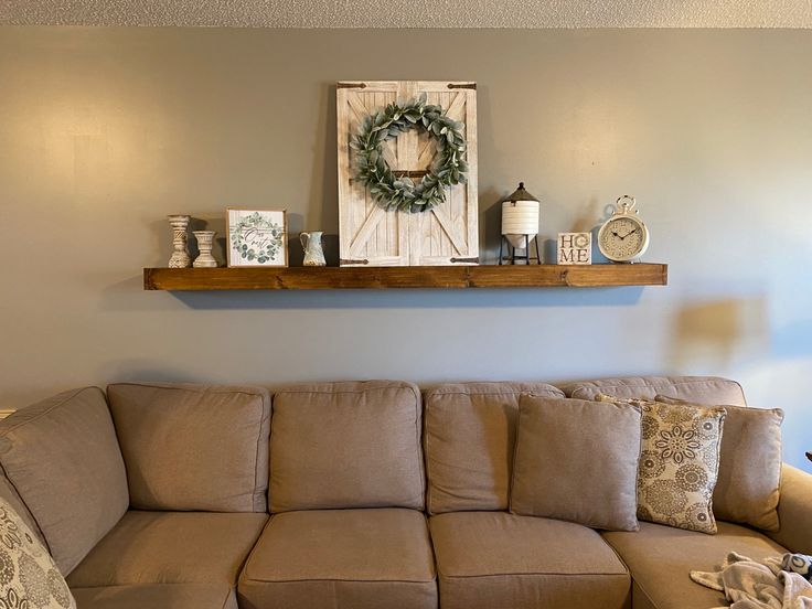 a living room with a couch, coffee table and clock on the shelf above it