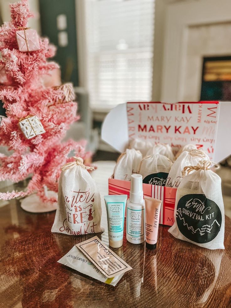 the contents of a personal care gift set on a table next to a pink christmas tree