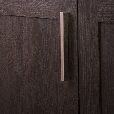 a close up of a door handle on a brown cabinet with wood grained doors