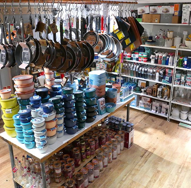 a room filled with lots of different types of pots and pans hanging from the ceiling