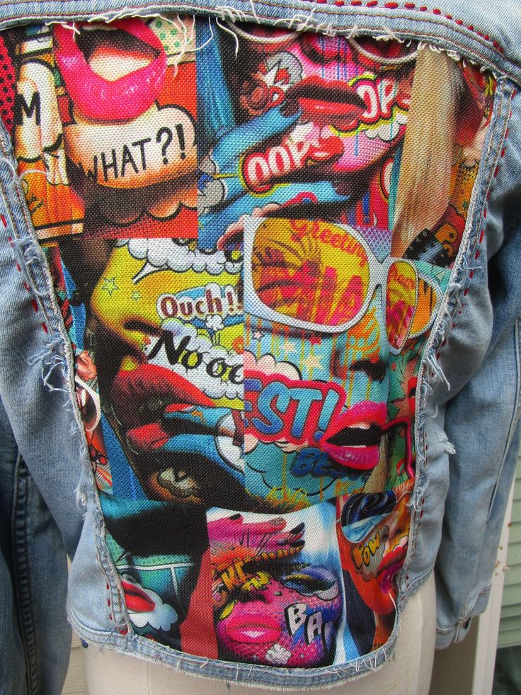 the back of a person wearing a jean jacket with colorful graffiti on it's back