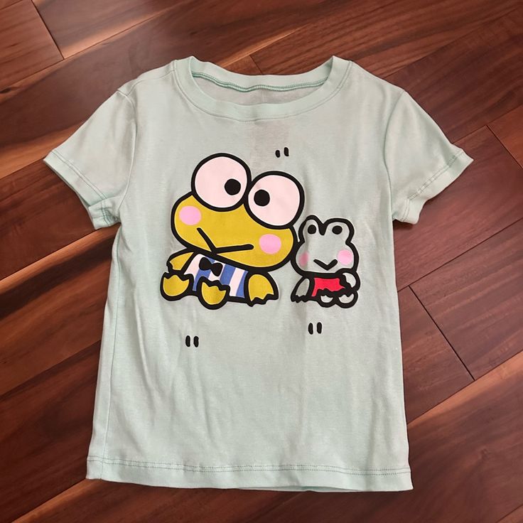 Sanrio Keroppi Mint Green Short Sleeve Graphic T-Shirt Juniors Size Xsmall New With Tags Girl Fit Has Stretch By Bioworld Trendy Cotton T-shirt For Playwear, Cotton T-shirt With Cartoon Print For Playwear, Green Summer T-shirt With Character Print, Summer Graphic Tee With Character Print, Playful Cartoon Print Tops For Spring, Casual Cartoon Print Short Sleeve Spring Tops, Casual Cartoon Print Short Sleeve Tops For Spring, Green Casual Top With Cartoon Print, Casual Green Tops With Cartoon Print