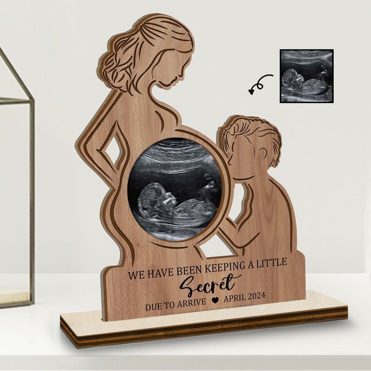 a wooden plaque with an image of a pregnant woman and her child in the center