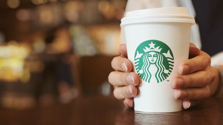 a person holding a starbucks cup in their hands