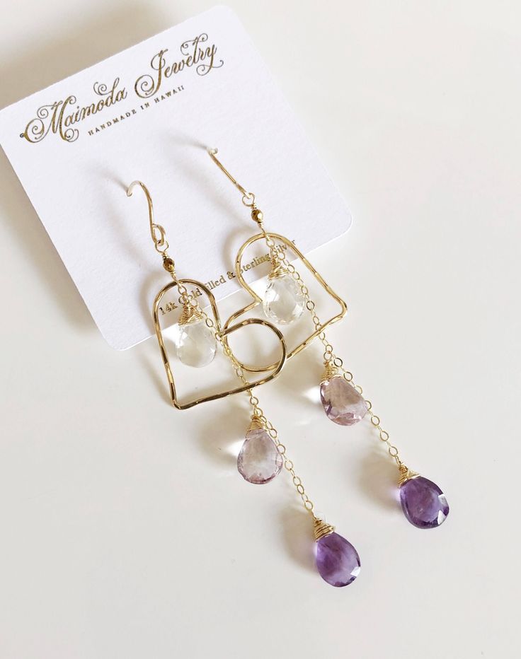 This earring is perfect to compliment any spring outfit with its purple ombré gemstone dangles and floating heart shape component. I used amethyst , pink amethyst and crystal quartz in this design. Hand shaped heart charm were slightly hammered for textures and shine, measured about 1.25 inches in size. Earring is about 3 inches long including ear wires. Handmade gold filled French ear wires. Dainty Dangle Heart Earrings With Ear Wire, Purple Dainty Earrings With Ear Wire, Pink Gold Dangle Earrings With Ear Wire, Purple Dangle Earrings With Ear Wire, Handmade Purple Dangle Heart Earrings, Heart Chandelier, Heart Earring, Purple Ombre, Sweet Heart