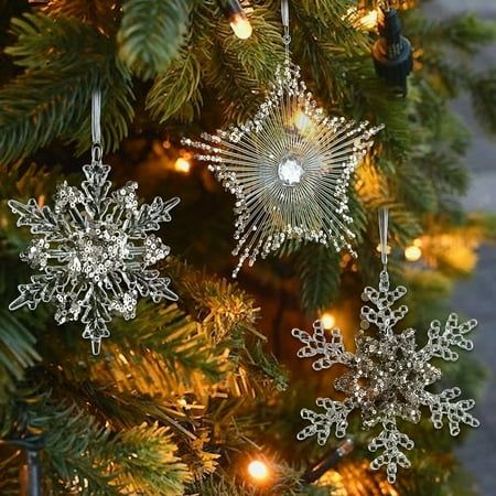 three snowflake ornaments hanging from a christmas tree