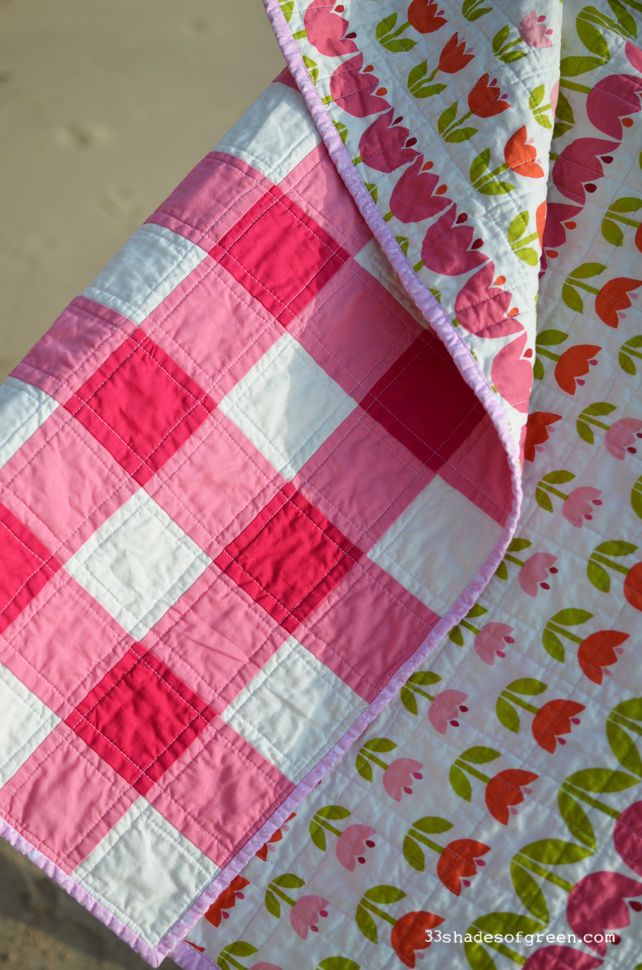 a pink and green checkered quilt hanging from a clothes line