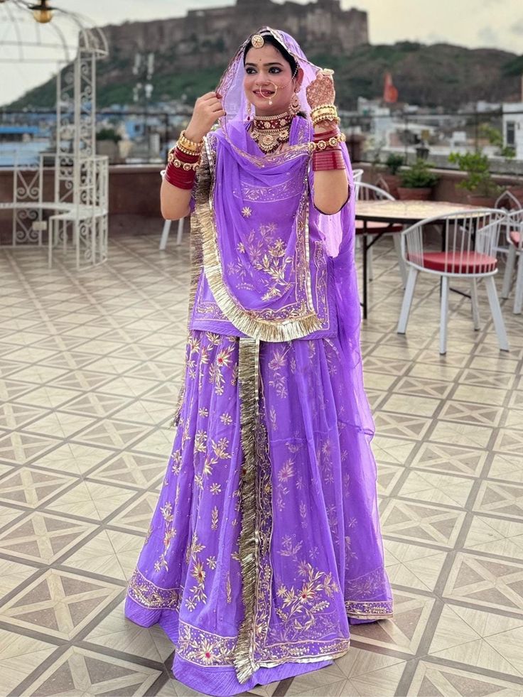 a woman in a purple outfit is posing for the camera