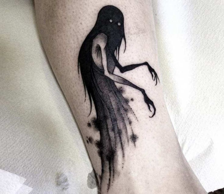 a woman's leg with a black and white tattoo on it