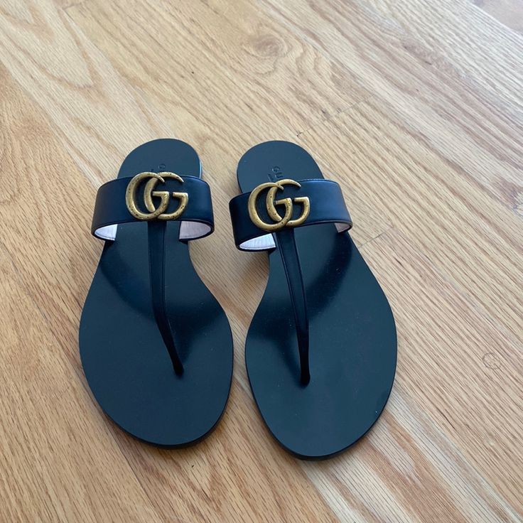 Authentic Gucci From Milan Store, Never Worn, Just Kept In Storage, Slick And Clean Leather, Slight Discoloration On G Over The Years Which Is Pictured, European Size 39 Fits U.S. Size 8.5/9 Gucci Designer Sandals With Single Toe Strap, Designer Gucci Sandals With Single Toe Strap, Chic Gucci Sandals With Single Toe Strap, Designer Toe Post Sandals, Gucci Black Sandals With Single Toe Strap, Luxury Black Leather Flip Flops, Elegant Gucci Flat Sandals, Designer Flat Flip Flops For Beach, Designer Black Toe Post Sandals