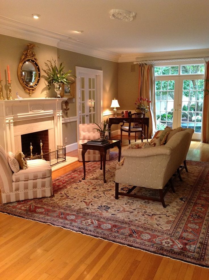 a living room filled with furniture and a fire place in the middle of a wooden floor