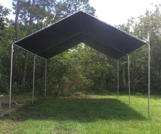 an open tent in the middle of a grassy area with trees and bushes behind it