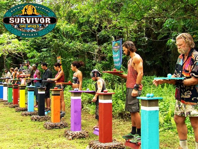 a group of men standing next to each other in front of some colorful poles and trees