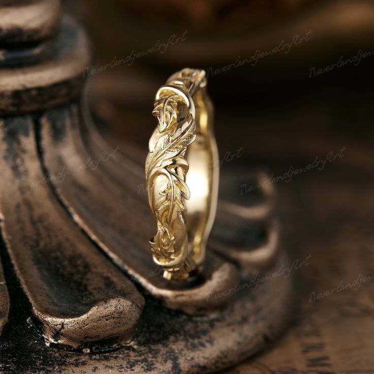 a gold wedding ring sitting on top of a wooden table