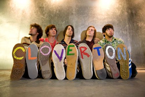 five men sitting in front of the word love written on their shoes, all lined up