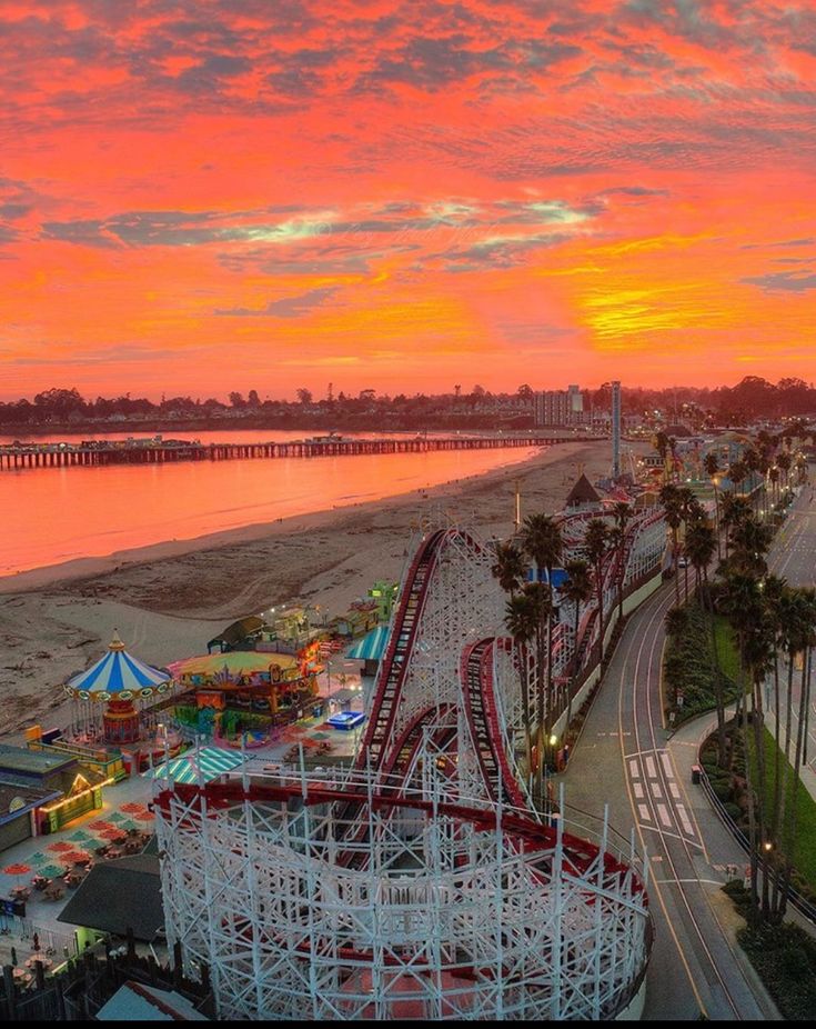 an aerial view of a carnival park at sunset