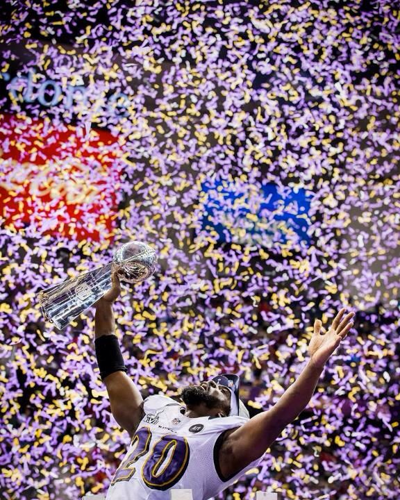 a football player holding up his trophy in front of confetti