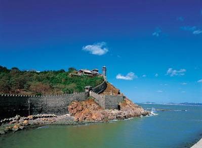 a large stone wall next to the ocean