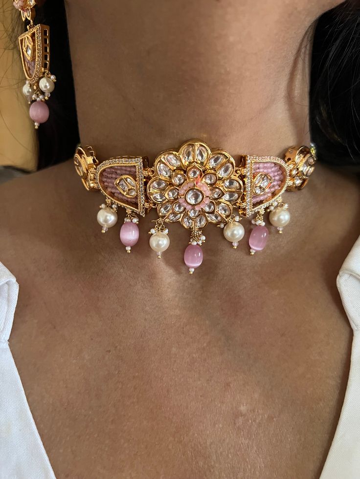 One of our favorite picks for the wedding season ♥️ The gorgeous choker is beautifully handcrafted by our skilled Indian craftsmen in Kundan stones, multi coloured beads, mini pearls, and gold plated. The beautiful Kundan earrings add to the traditional ethnicity of the piece. Material: Brass with gold plating Dimensions Weight of choker is 39 g. Choker comes with adjustable Dori. Weight of earrings is 18 g per pair. Length of earrings: 6.55 cms, push back closure. Width of earrings: 2.5 cms. Multicolor Gold Beaded Jewelry For Wedding, Festive Handmade Pearl Jewelry, Elegant Pink Meenakari Jewelry, Pink Bridal Choker Necklace As Gift, Pink Choker Bridal Necklace Gift, Pink Celebration Jewelry With Jewels, Pearl Kundan Choker Necklace For Gift, Kundan Jewelry With Gold Beads For Party, Pink Kundan Choker Jewelry