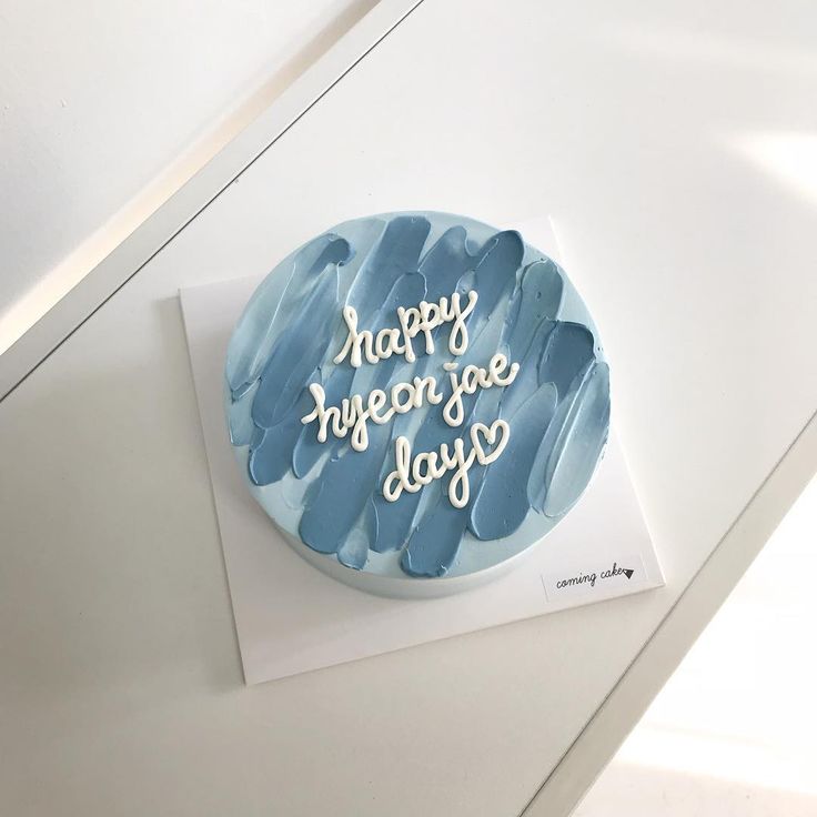 a blue cake with white frosting that says happy in the day on it's side