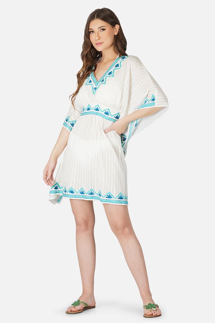 Cute as a button, retro like lyrics, made for a day out in the sun, the Sea Blue Embroidered Kaftan loves long drives, Sunday brunches and lots of pictures. Featuring intricate hand embroidery in shades of blue, a V neckline, elastic waist and an above knee length, this cutie will take you through tropical vacations and swim trips alike. On a neutral white with lurex stripes, the blue hand embroidery really powers through and reminds us of a calm blue sea. Style with happy jewels, a pair of flat Summer V-neck Tunic With Chikankari Embroidery, Light Blue Embroidered Beach Dress, Summer V-neck Embroidered Kaftan, Blue Bohemian Chikankari Embroidered Dress, Bohemian Blue Chikankari Embroidered Dress, Blue Bohemian Dress With Chikankari Embroidery, Floral Embroidered Tunic For The Beach, Embroidered Tunic For Spring Vacation, Embroidered Beach Dress Cover-up For Spring