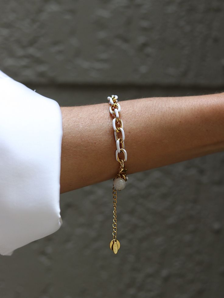 The white enamel on the gold chain bracelet adds a sleek and elegant touch, while the stainless steel base provides durability. Chain is made of stainless steel, gold ION plated with 18k gold. This bracelet effortlessly elevates any ensemble, making a bold yet refined statement. Elegant and stylish, it's a versatile accessory that complements both formal and trendy attire, adding a touch of luxury to any look. Length of the chain is 16 inches including the clasp. There is 2'' extender chain for White Chain Bracelet Jewelry, Modern White Jewelry With Delicate Chain, Modern White Metal Chain Bracelet, White Chain Bracelet, Dainty White Chain Bracelet, White Dainty Chain Bracelet, Elegant White Bracelets With Gold Chain, Modern White Bracelets With Adjustable Chain, Elegant White Everyday Chain Bracelet